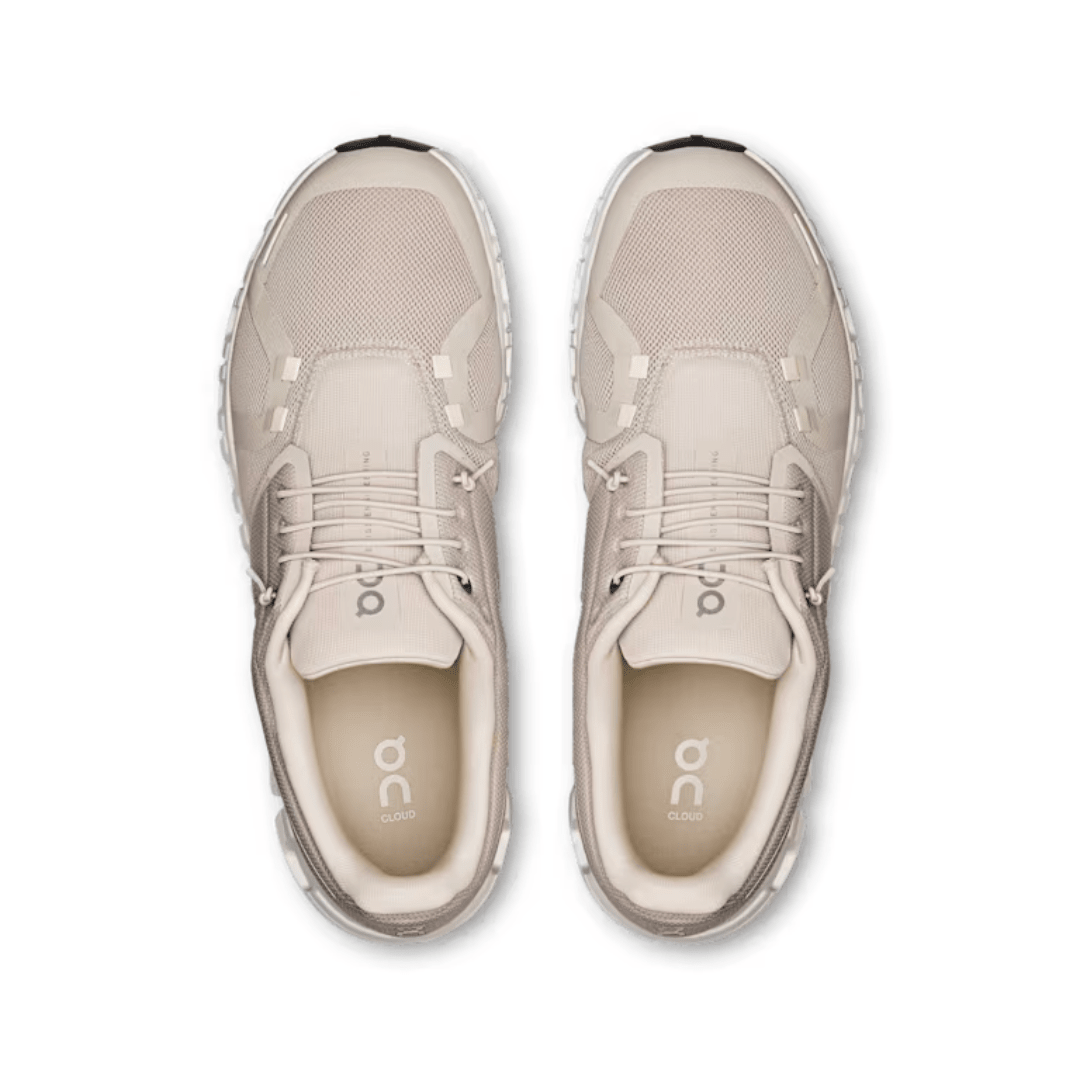 Pair of beige running shoes on a white background