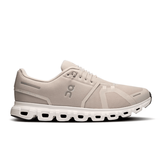 Beige running shoe with white sole on a white background