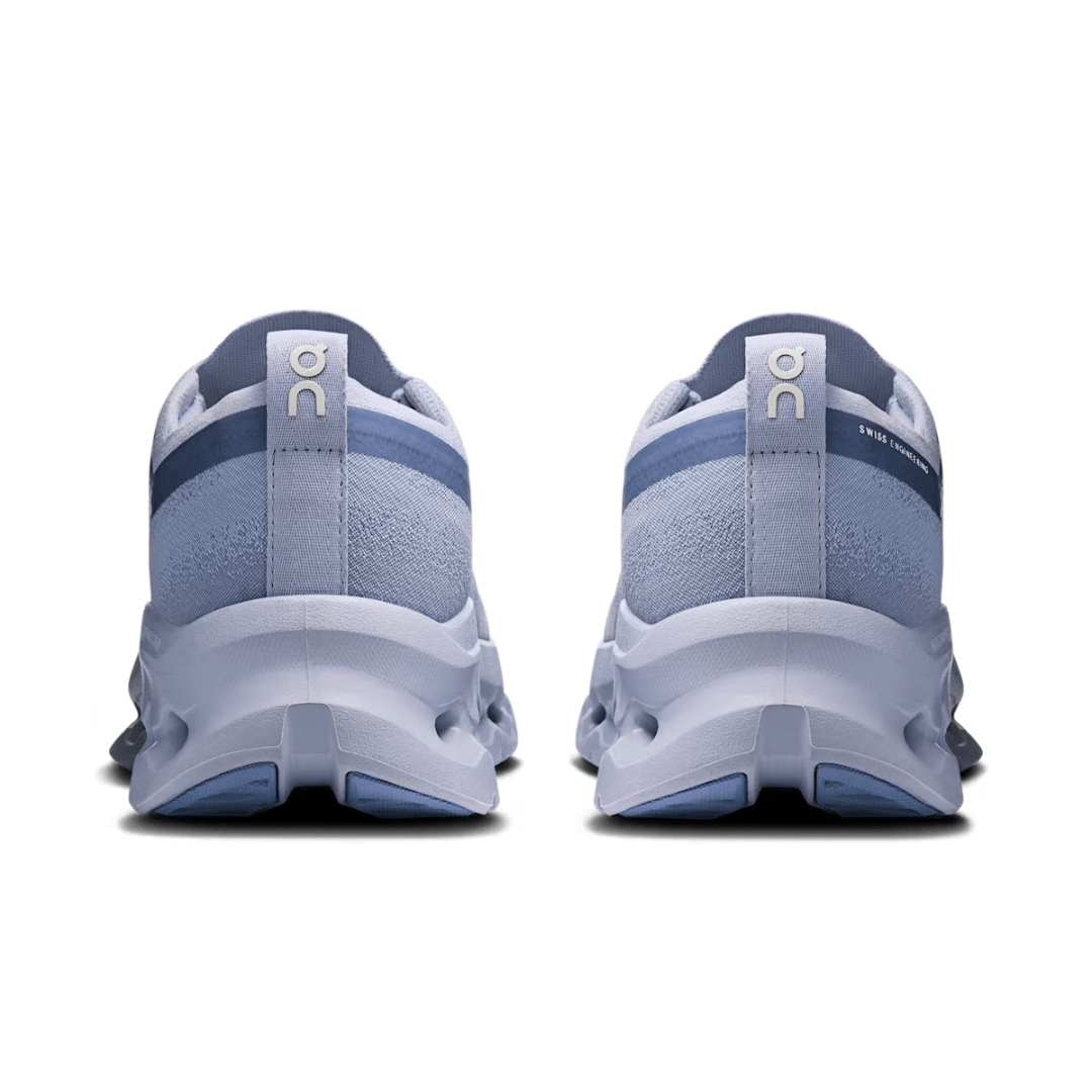 Pair of blue running shoes with white soles on a white background