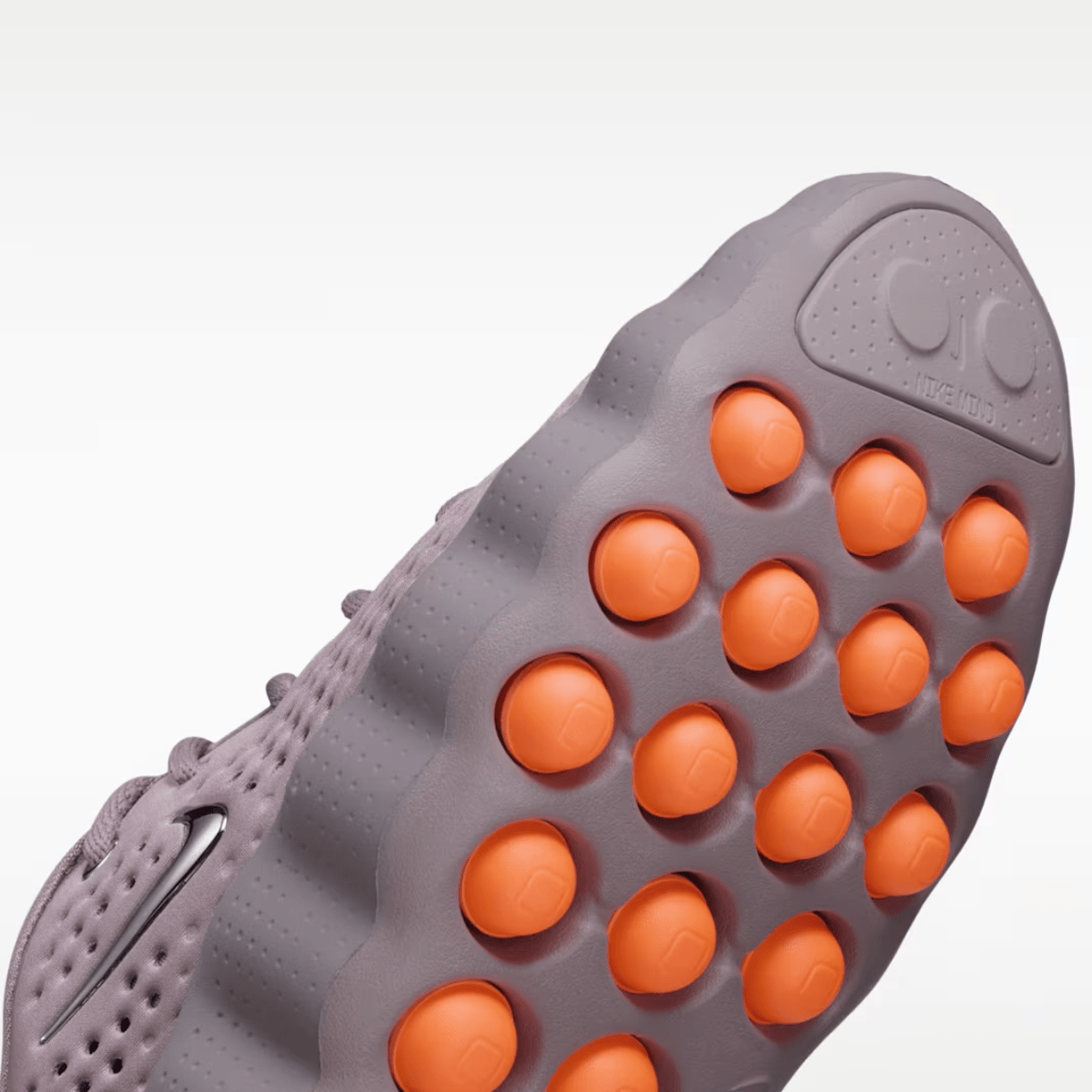 Close-up of a shoe sole with orange凸起 on a white background