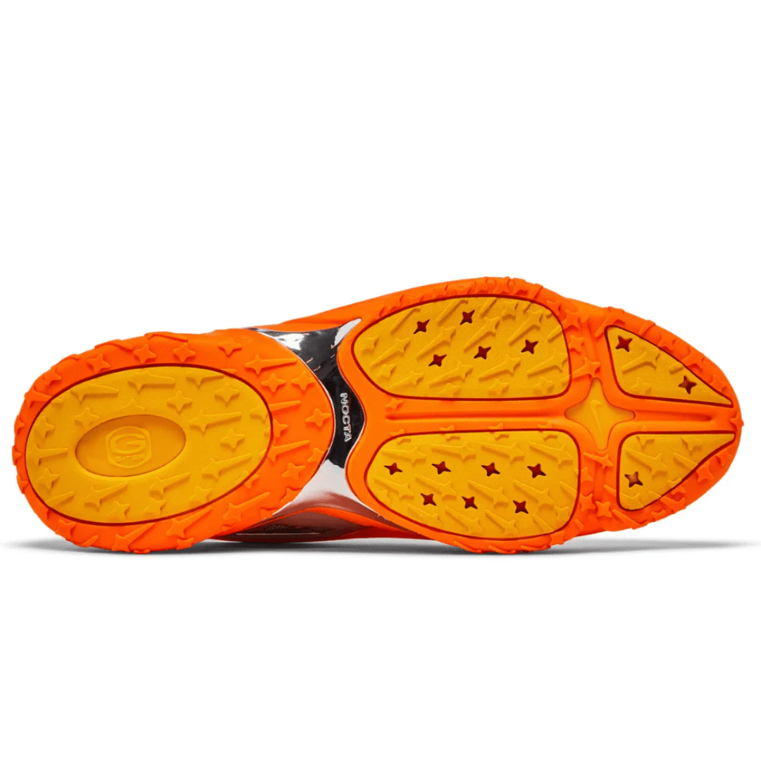 Lifestyle shot of Nike Nocta Hot Step 2 Total Orange sneakers in UAE city background.