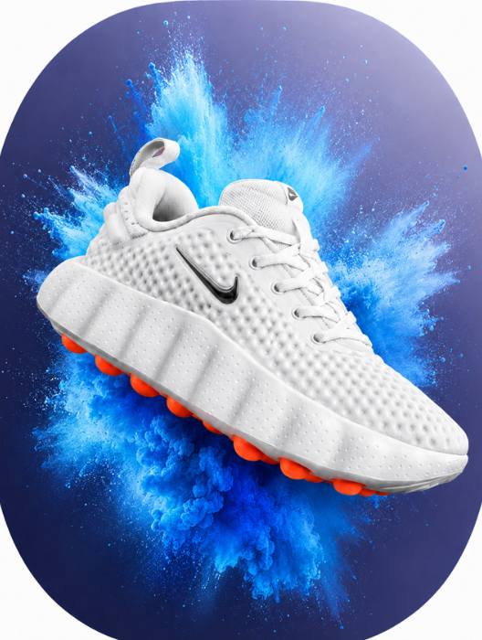 White sneaker with orange sole on a blue powder explosion background