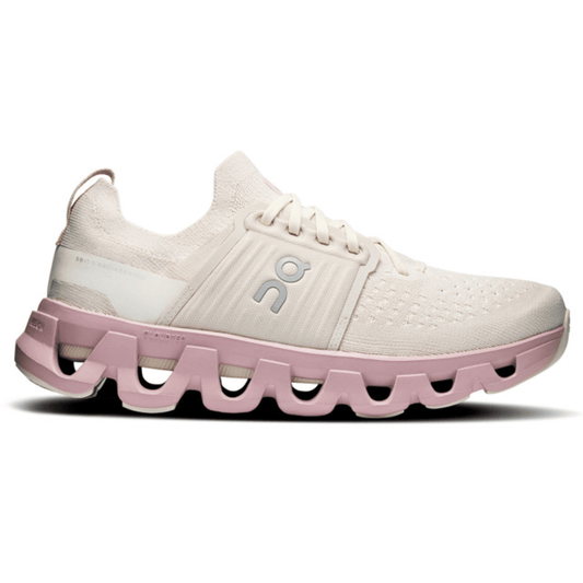 White and pink running shoe with unique sole design on a white background