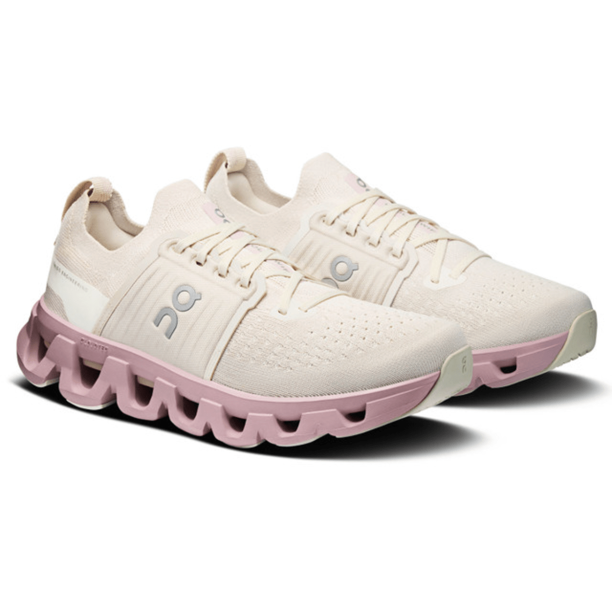 White and pink athletic shoes with a unique sole design on a white background